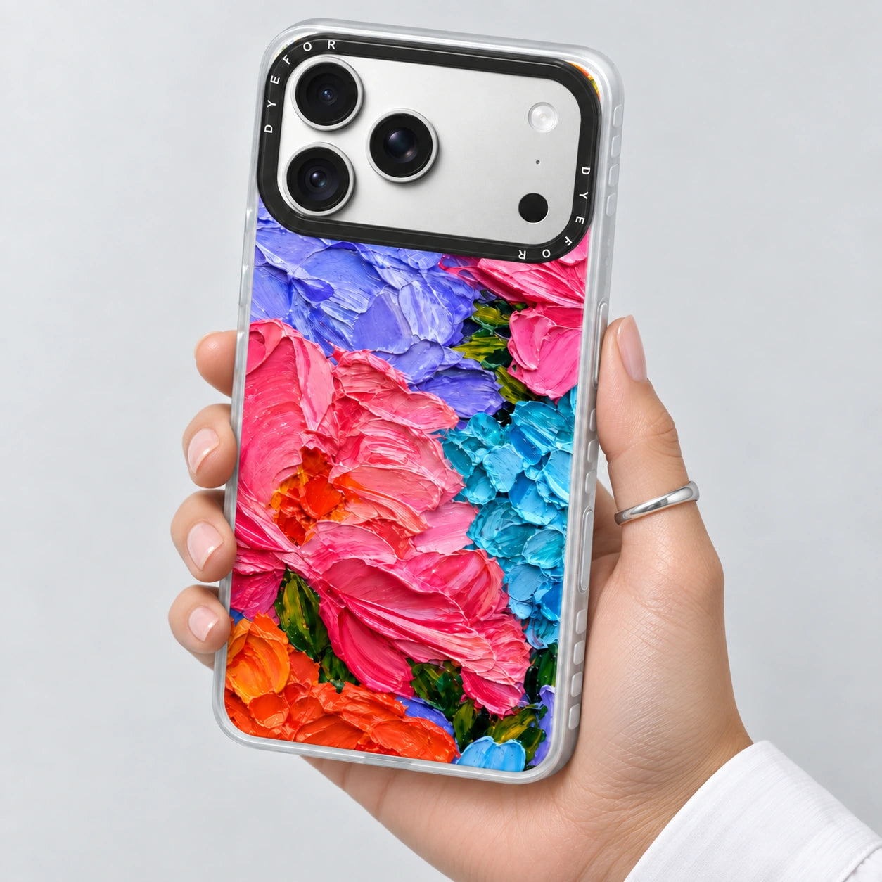 Bloom Riot's vivid pink, lilac and blue floral phone case held in one hand