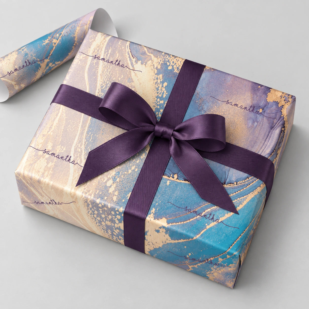 Personalised pink and blue marble wrapping paper with a plum satin bow